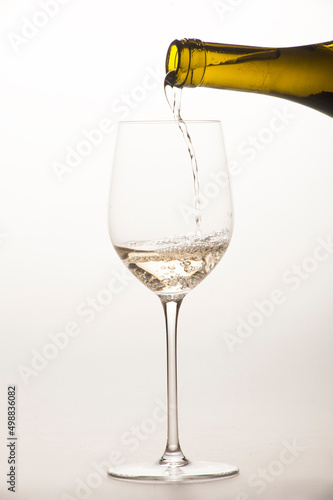 white wine is poured into a special glass on a light background in the studio close-up without a person