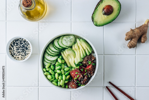 Poke bowl with raw tuna, rice, avocado, edamame beans and cucumber in a bowl. Hawaiian ahi poke bowl photo
