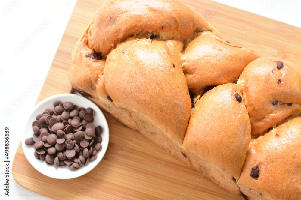 Artisanal bread with a touch of chocolate, displayed on white wood Artisanal bread with a touch of chocolate, displayed on white wood