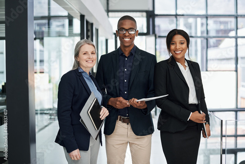 The word impossible doesnt exist in our work. Portrait of a group of businesspeople working together in a modern office.