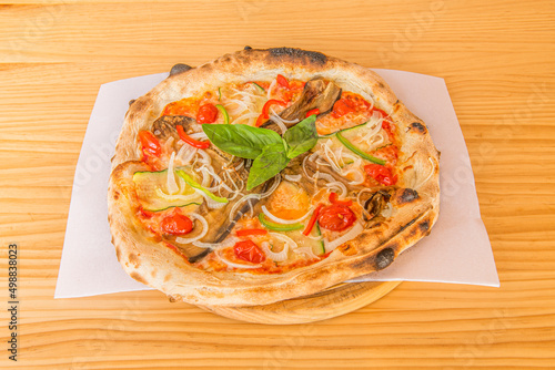 Pizza with products from the garden, white onion, cherry tomatoes, courgette and aubergine, basil and olive oil