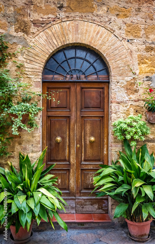 A wooden door with a half round frosted glass above