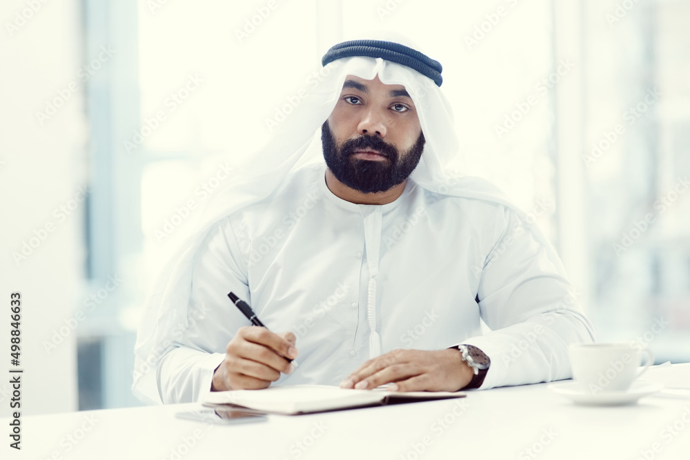 Im here to achieve my dreams. Cropped portrait of a young businessman dressed in Islamic traditional clothing working in his office. Im here to achieve my dreams. Cropped portrait of a young businessman dressed in Islamic traditional clothing working in his office.