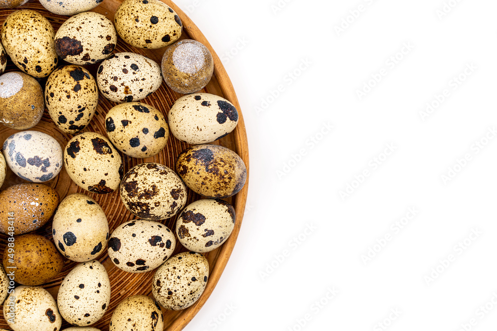 Raw quail eggs on a white background on a plate, top view, healthy eating concept Raw quail eggs on a white background on a plate, top view, healthy eating concept