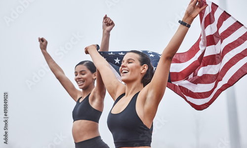 Fototapeta Naklejka Na Ścianę i Meble -  Women run the world. Shot of female athletes celebrating their win while holding a flag.