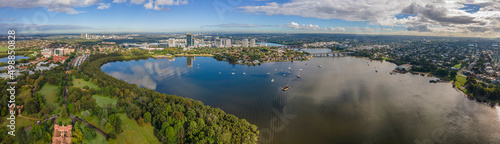 Panoramic aerial drone view of Rhodes, an Inner West suburb of Sydney looking over McIlwaine Park and Brays Bay at Ryde Bridge along Parramatta River  