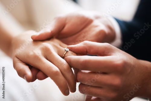 No diamond can compare to this precious love. Cropped shot of an unrecognizable groom putting a diamond ring on his wifes finger during their wedding.
