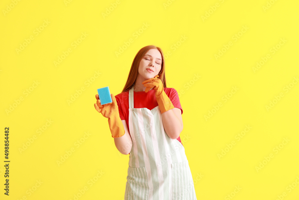 Thoughtful young woman with sponge on color background Thoughtful young woman with sponge on color background