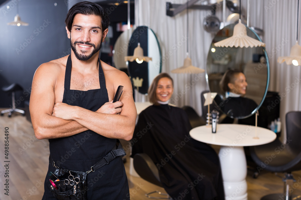 adult positive male hairdresser and female client in beauty salon