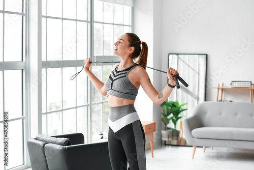 Slika na platnu Sporty young woman with skipping rope at home