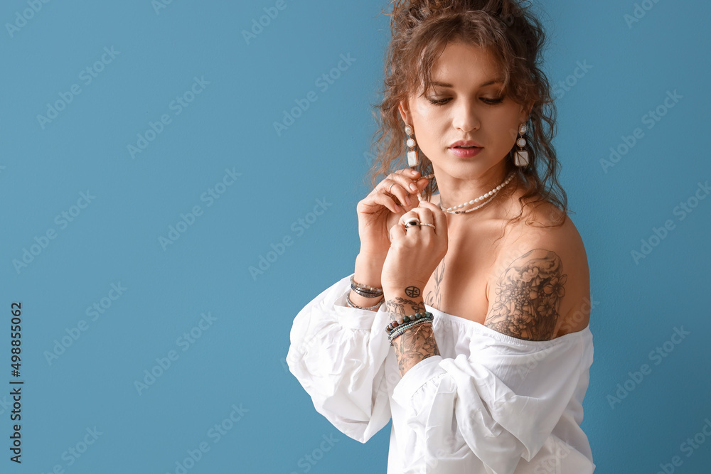 Beautiful tattooed woman on blue background