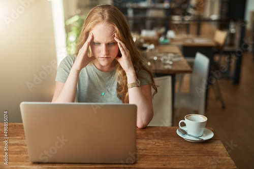 Slow connection will ruin your day. Cropped shot of a young woman looking stressed while sitting in front of her laptop.