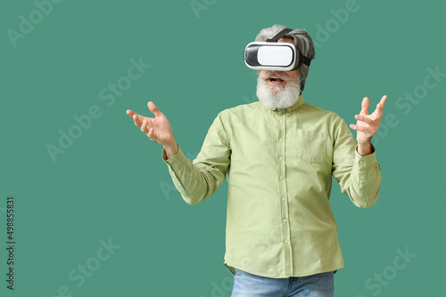 Senior man in VR glasses on...