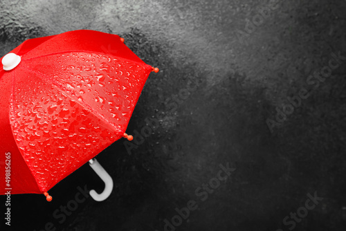 Red umbrella with water drops on dark background  closeup