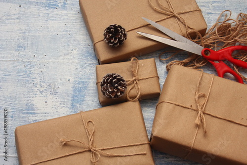 gift wrapping from Kraft paper wrapped with twine, the concept of handmade, light blue tabletop.