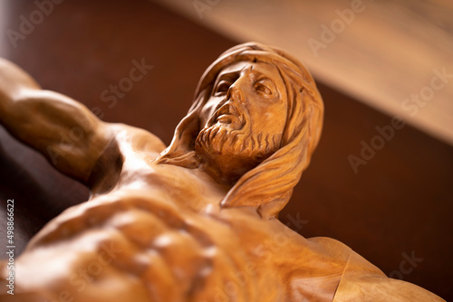 Fototapeta Naklejka Na Ścianę i Meble -  Religion theme - Jesus Christ. Cruciefied Jesus figure isolated on wooden brown background.