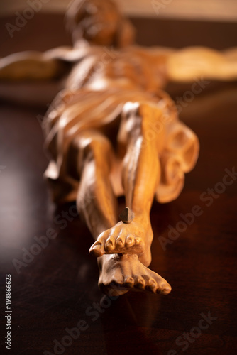 Religion theme - Jesus Christ. Cruciefied Jesus figure isolated on wooden brown background.