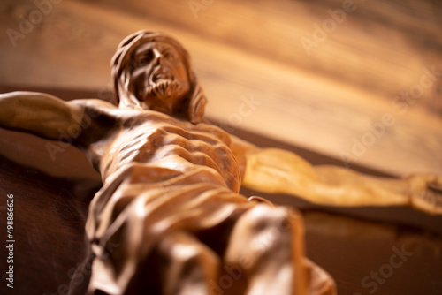 Religion theme - Jesus Christ. Cruciefied Jesus figure isolated on wooden brown background.