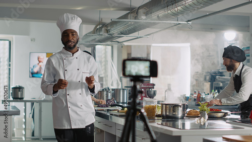 Foto African american chef recording cooking show TV program, broadcasting online gastronomy class with camera