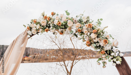 Wedding round arch with flowers and fabric in spring or winter. The place of the bride and groom for the ceremony in nature