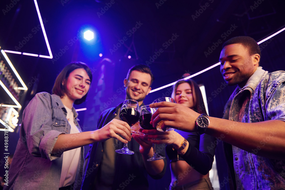 People doing cheers. Group of friends having fun in the night club together People doing cheers. Group of friends having fun in the night club together