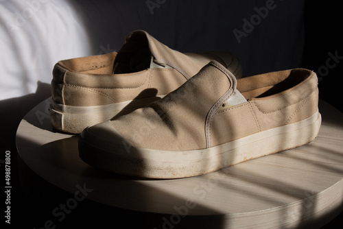 a pair of cream-colored shoes, kept on a round table