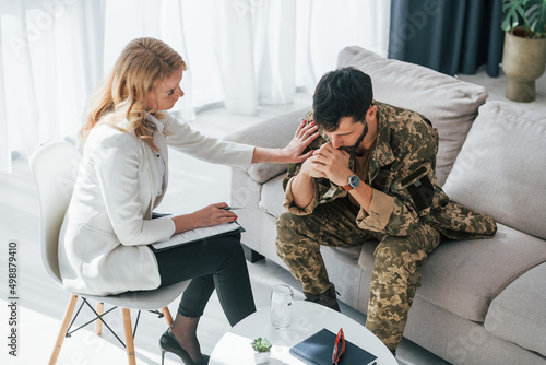 Post traumatic stress disorder. Soldier have therapy session with psychologist indoors photo