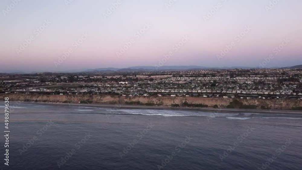 A beautiful aerial drone shot, flying towards the coast with a view of a town, the horizon, and mountains, Carlsbad State Beach - California A beautiful aerial drone shot, flying towards the coast with a view of a town, the horizon, and mountains, Carlsbad State Beach - California