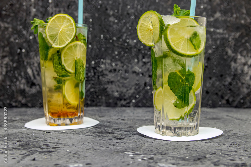 Fototapeta premium Mojito cocktail drink with lime and mint on dark background with copy space