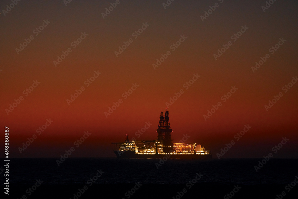 Distant majestic view of ship that is in the ocean at evening time