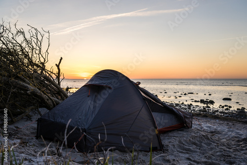 Fototapeta Naklejka Na Ścianę i Meble -  Grey and red tent at the beach in sunset conditions