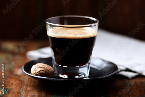 Coffee in glass cup on dark wooden background. Close up. 