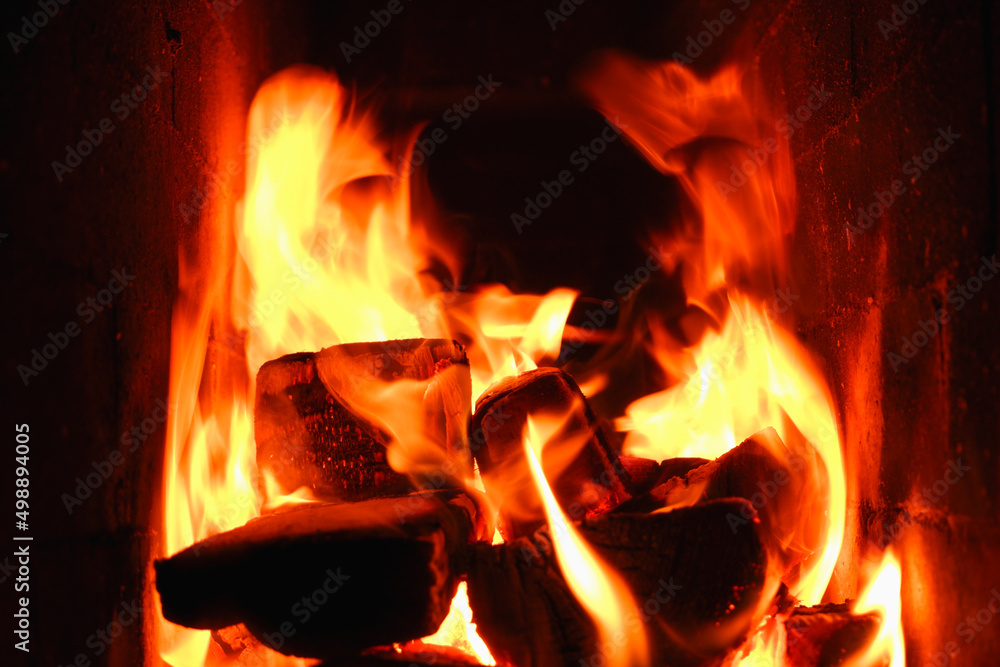 Burning firewood and coals in a stone stove. Brick oven on wood. Long tongues of flame of burning fire Burning firewood and coals in a stone stove. Brick oven on wood. Long tongues of flame of burning fire