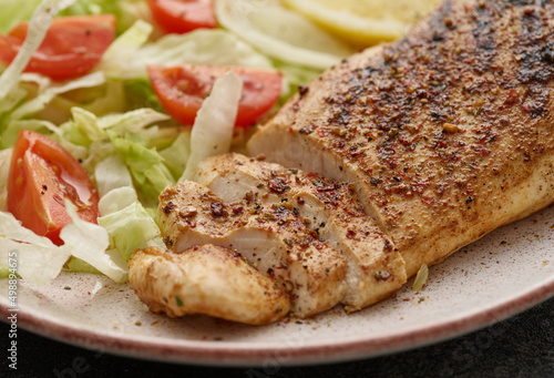 Fried chicken breast. Grilled chicken breast with vegetable salad and lemon