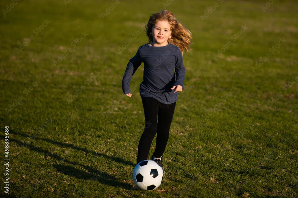 Soccer kid. Kids play football on summer stadium field. Little child boy kicking ball. Cute boy kicking soccer ball. Soccer kid. Kids play football on summer stadium field. Little child boy kicking ball. Cute boy kicking soccer ball.
