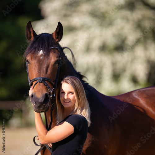 Portrait of a young girl with her horse, image format 1:1, motif isolated against a blurred background..
