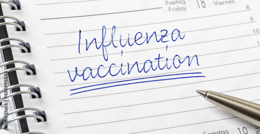 Influenza Vaccination written on a calendar page Influenza Vaccination written on a calendar page