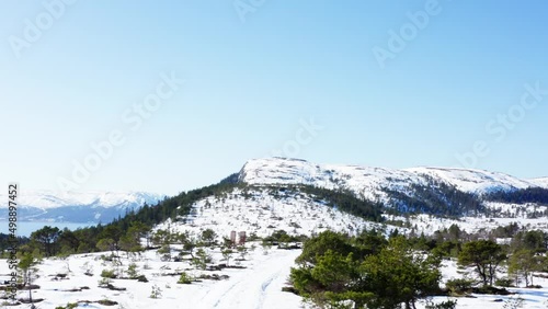 Snowy Landscape And Hill View Of Blaheia, Nordland Norway During Winter Season Overlooking A Clear Sky- Forward Aerial Shot photo