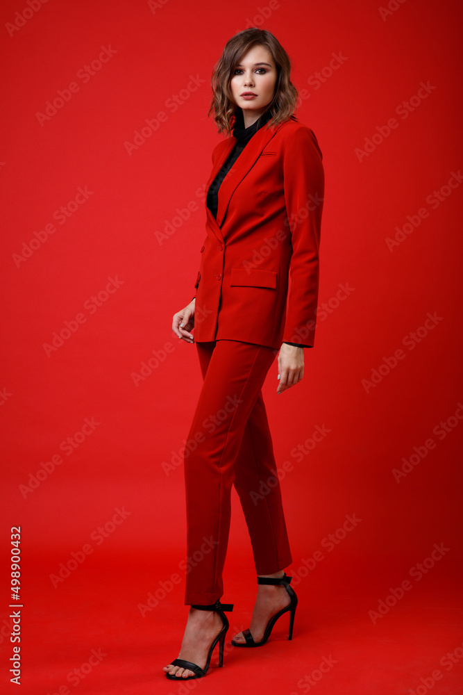 High fashion photo of a beautiful elegant young woman in a pretty red suit, jacket, pants, trousers, black blouse posing on background. Slim figure, hairstyle, studio shot. Monochrome, total red High fashion photo of a beautiful elegant young woman in a pretty red suit, jacket, pants, trousers, black blouse posing on background. Slim figure, hairstyle, studio shot. Monochrome, total red