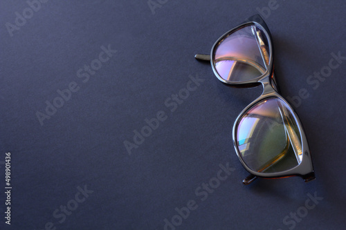 Anti-glare coating on the glasses. Glasses with black frames on a dark background.