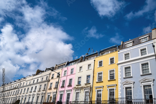 Colourful terraced townhouses with summer sky background. Notting Hill, London, is famous for streets of houses with brightly painted exteriors.