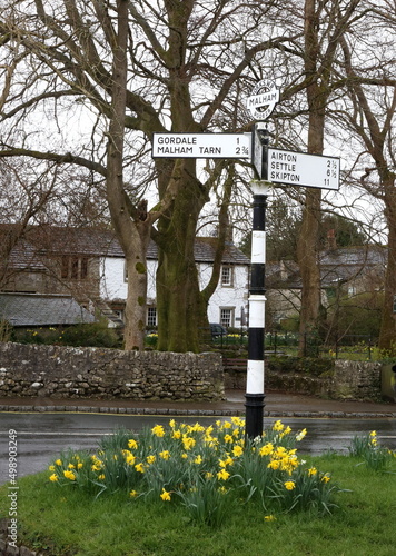 Old fashioned road sign in the village of Malham, Yorkshire showing direction and distance to nearby villages.