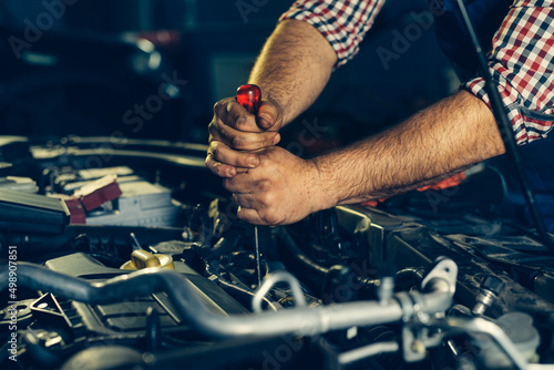 Car mechanic checking oil level in a mechanical workshop © zorandim75