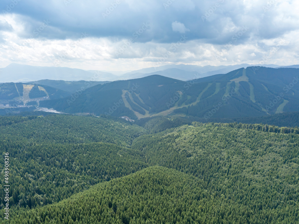 Fototapeta premium Green mountains of Ukrainian Carpathians in summer. Sunny day, rare clouds. Aerial drone view.
