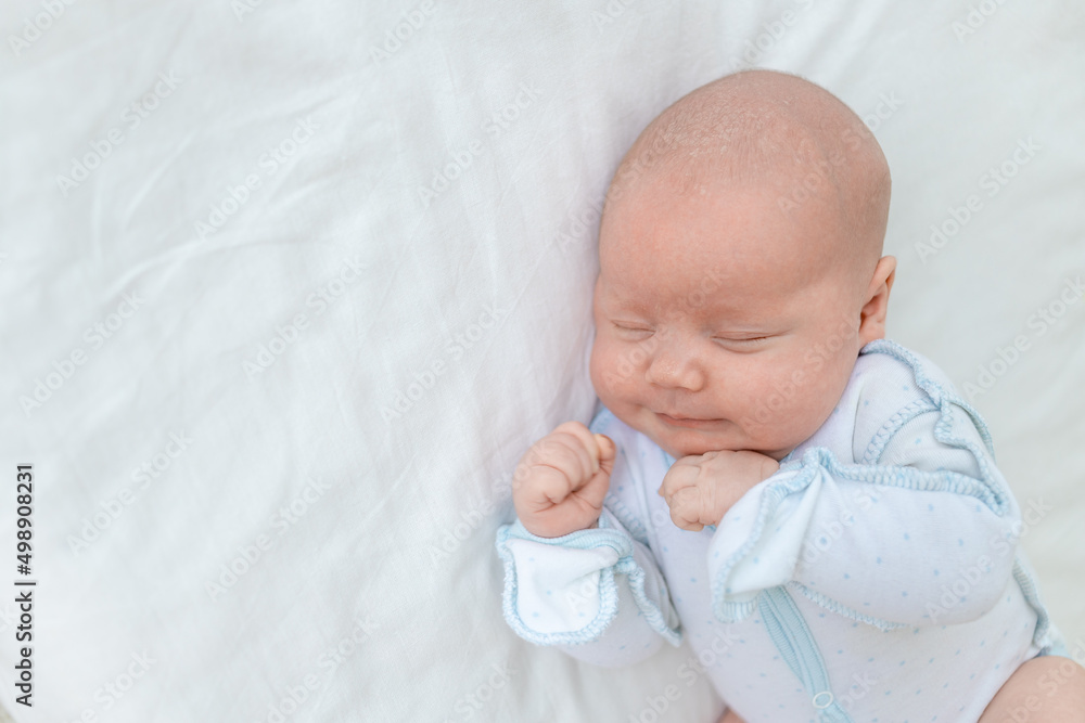 newborn baby boy sleeps seven days in a cot at home on a cotton bed, close-up newborn baby boy sleeps seven days in a cot at home on a cotton bed, close-up