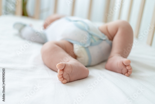 newborn baby's feet on white cotton bed at home close-up