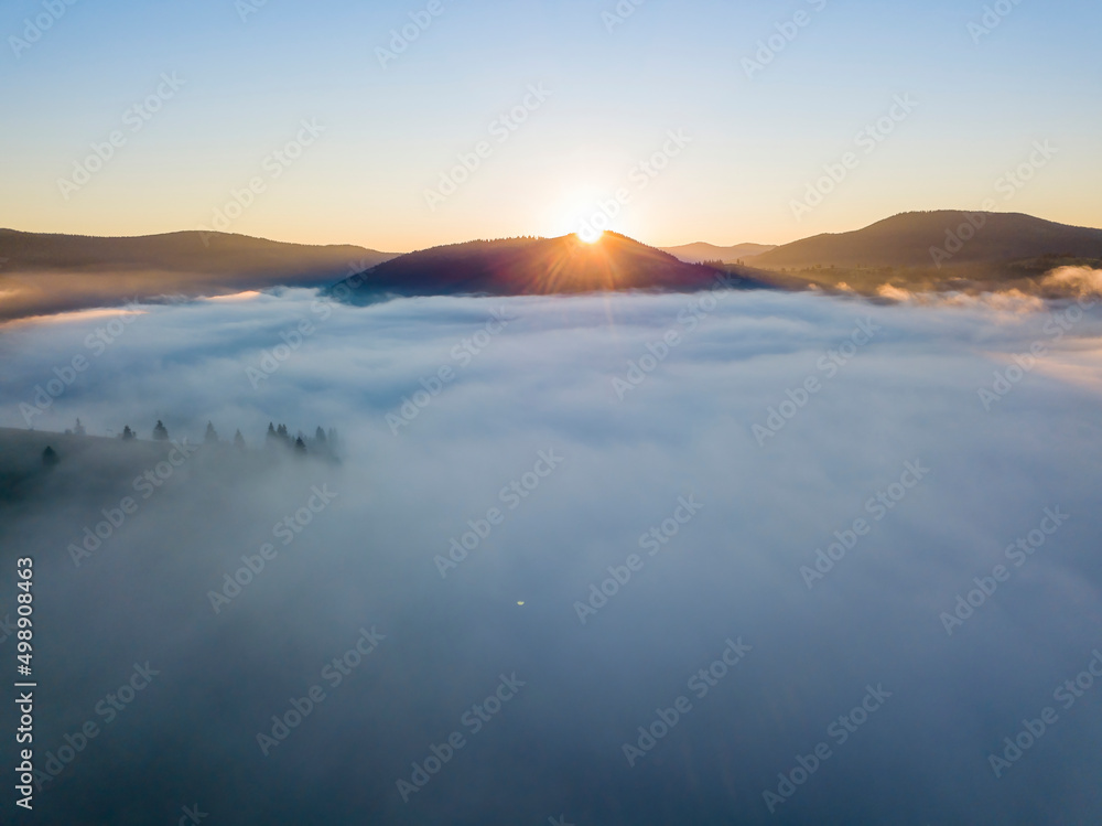 Sunrise over the fog in the Ukrainian Carpathians. Aerial drone view.