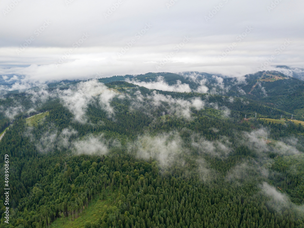 Green slopes of Ukrainian Carpathian mountains in summer. Cloudy morning, low clouds. Aerial drone view. Green slopes of Ukrainian Carpathian mountains in summer. Cloudy morning, low clouds. Aerial drone view.