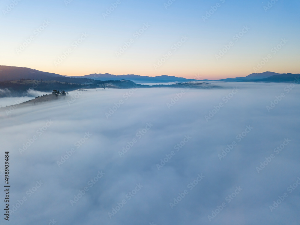 Sunrise over the fog in the Ukrainian Carpathians. Aerial drone view.