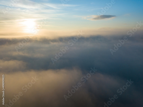 The rays of dawn over the fog in the Ukrainian Carpathians. Aerial drone view.